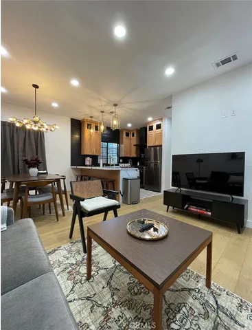 a living room with furniture a flat screen tv and kitchen view