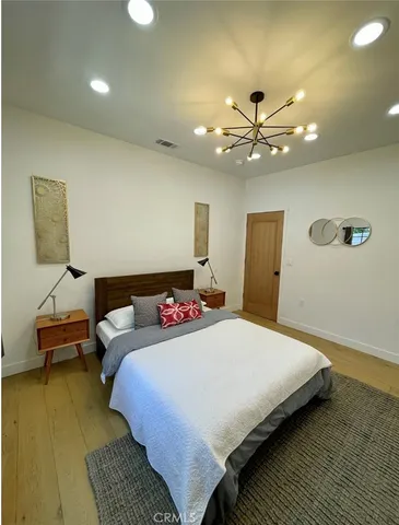 a bedroom with a bed and a chandelier