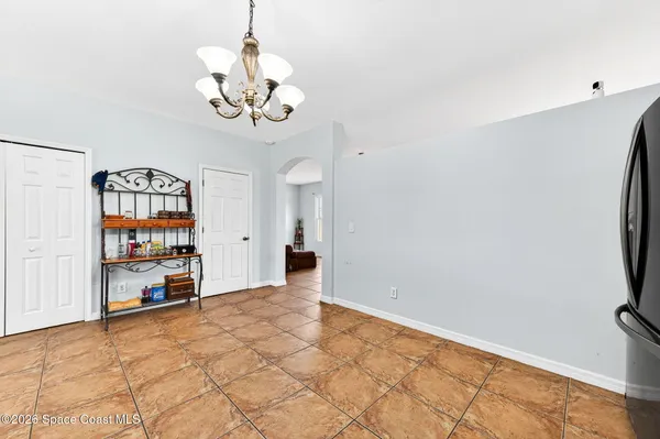 a view of an empty room with workspace and a chandelier fan