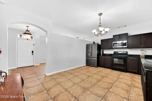 a kitchen with granite countertop a refrigerator and a stove top oven