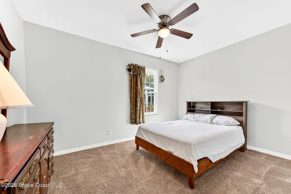 a bedroom with a bed and a ceiling fan