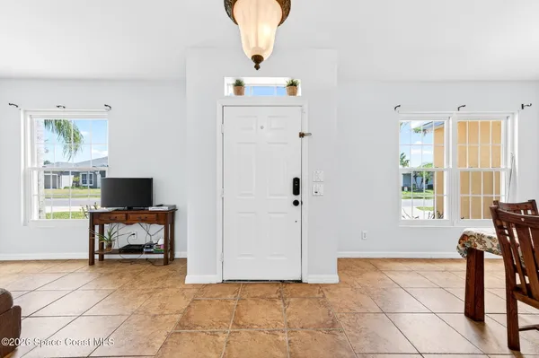 a living room with furniture a flat screen tv and a window