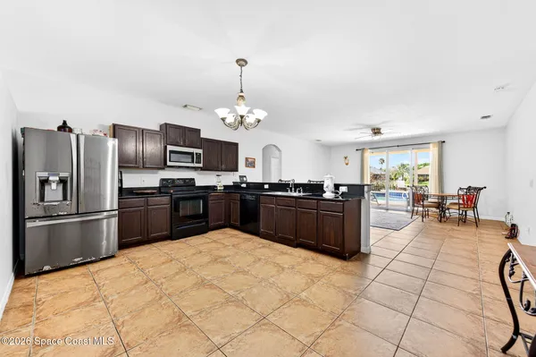 a large kitchen with granite countertop a large counter top stainless steel appliances and cabinets