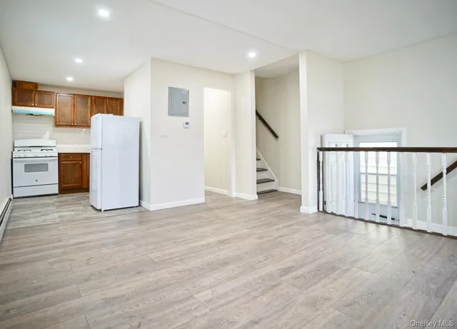 a view of a kitchen with stainless steel appliances wooden floor and windows