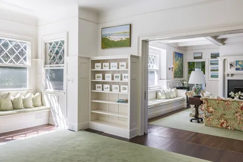 a living room with fireplace furniture and a large window
