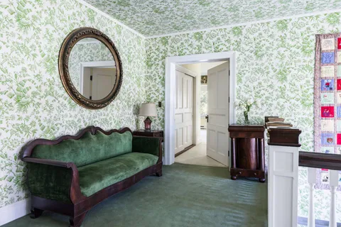 a bedroom with a bed and large windows