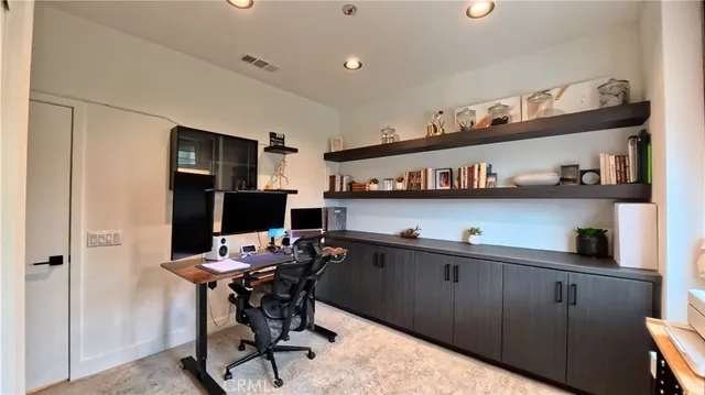 a kitchen with a refrigerator and a flat screen tv