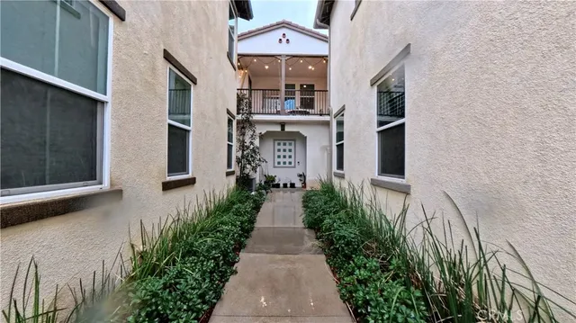 a view of a brick house with many windows next to a yard