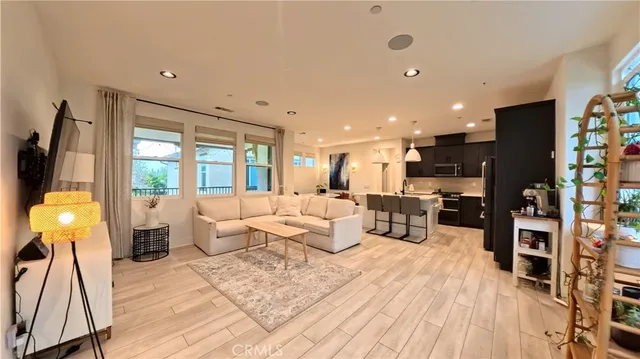 a living room with furniture a large window and wooden floor