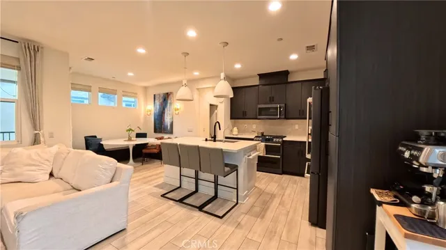 a living room with furniture a rug and kitchen view