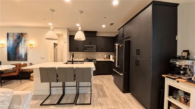 a kitchen with stainless steel appliances kitchen island granite countertop a refrigerator and a stove top oven