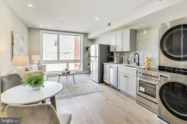 a kitchen with a sink a stove cabinets dining table and chairs