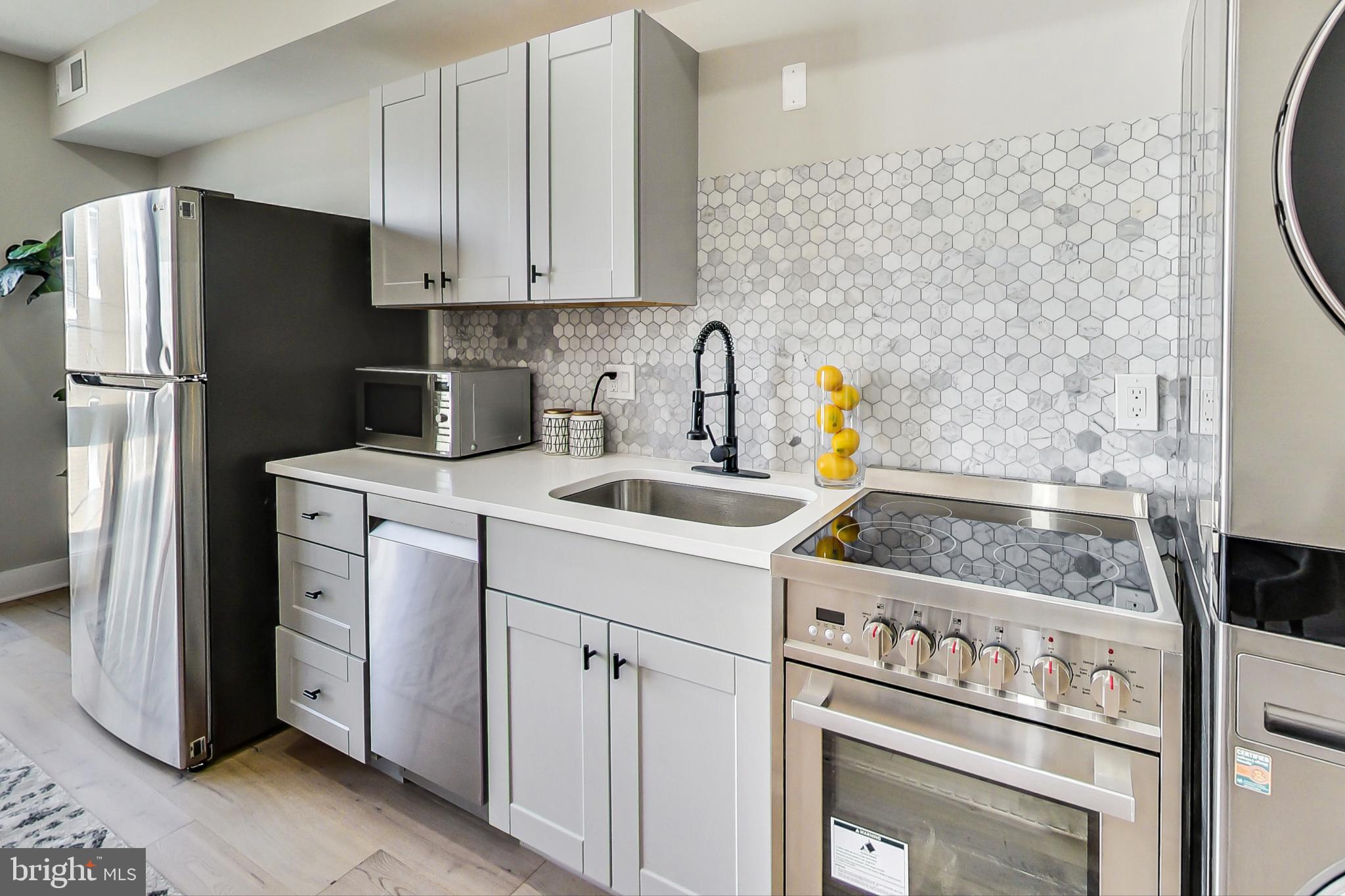 207 Florida Avenue Northwest, Unit 2 Washington, DC 20001 - Photo 9 of 18 a kitchen with stainless steel appliances white cabinets a sink and a stove