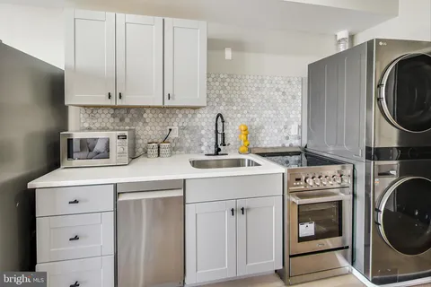 a kitchen with cabinets washer and dryer