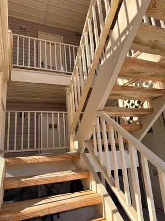 a view of staircase with railing and white walls