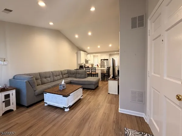 a living room with furniture and a wooden floor