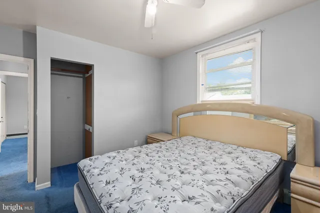 a bedroom with a bed and a window with wooden floor