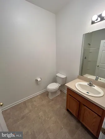 a bathroom with a granite countertop sink a toilet and a mirror