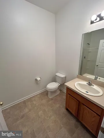 a bathroom with a granite countertop sink a toilet and a mirror