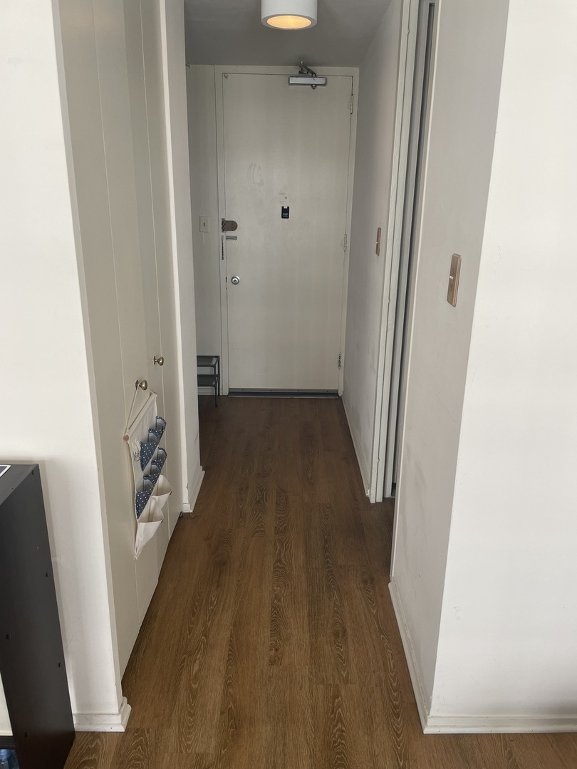 1400 East 55th Place, Unit 613S Chicago, IL 60637 - Photo 8 of 12 a view of a hallway with wooden floor and staircase