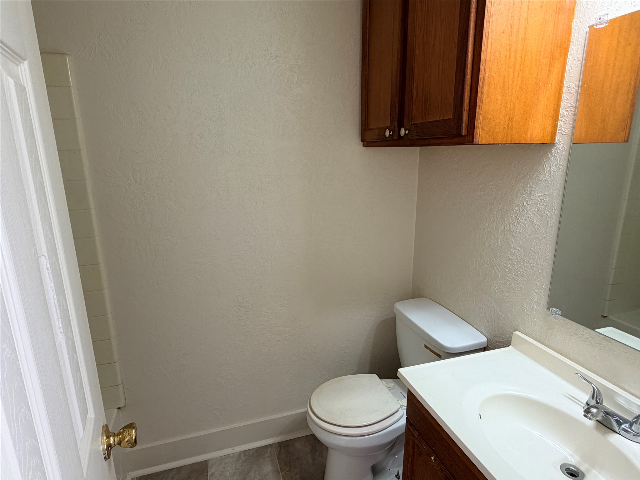 500 West Third Street Brenham, TX 77833 - Photo 13 of 16 a white toilet sitting next to a bathroom sink