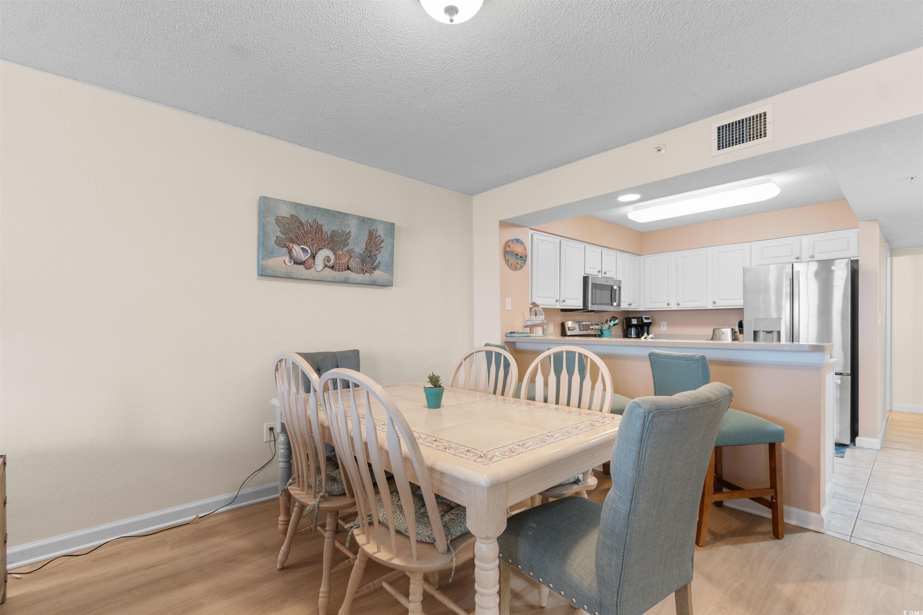 1003 South Ocean Boulevard, Unit 902 North Myrtle Beach, SC 29582 - Photo 10 of 40 Dining space featuring light wood-style floors and a textured ceiling