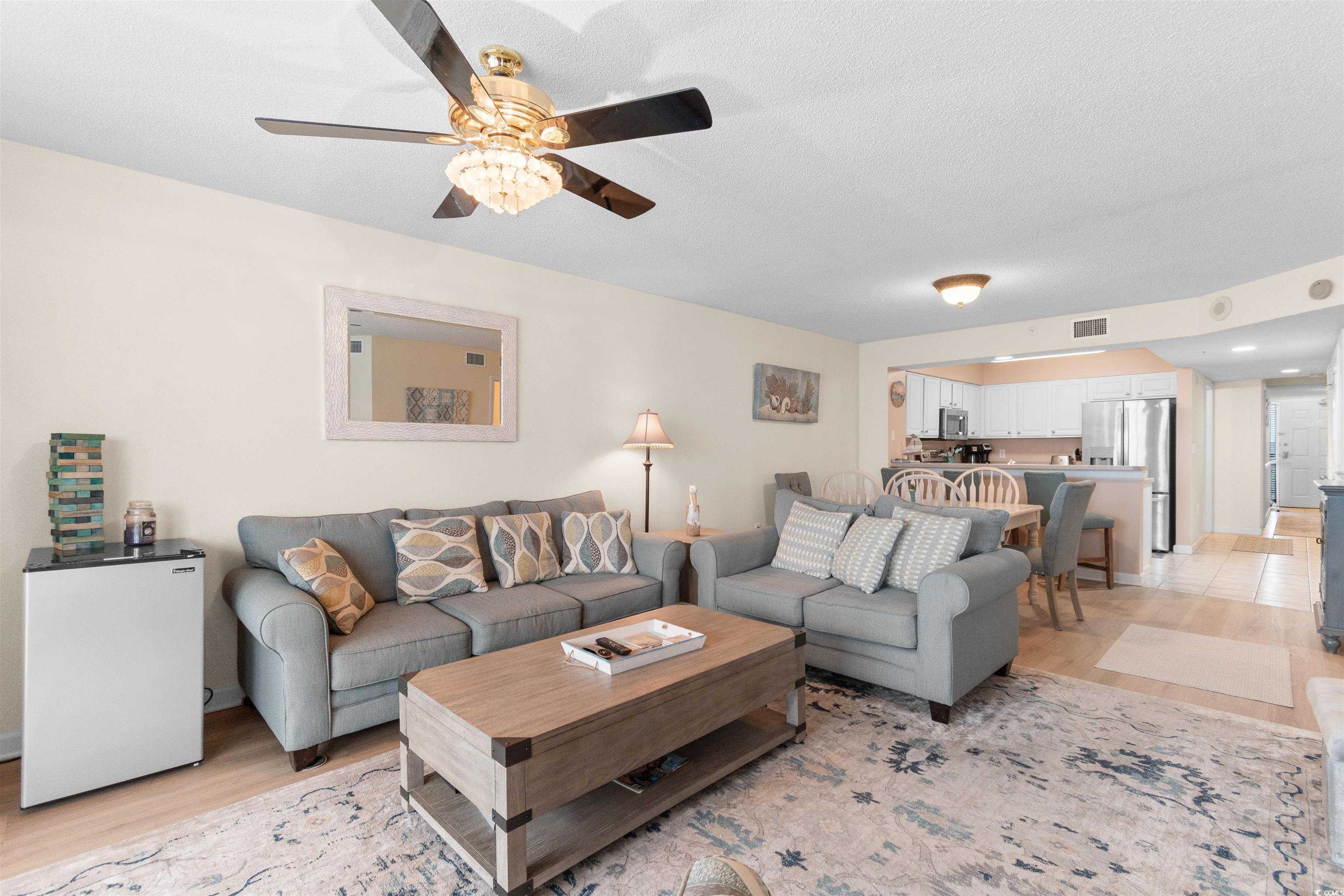 1003 South Ocean Boulevard, Unit 902 North Myrtle Beach, SC 29582 - Photo 15 of 40 Living room featuring light wood-style floors, a textured ceiling, and ceiling fan