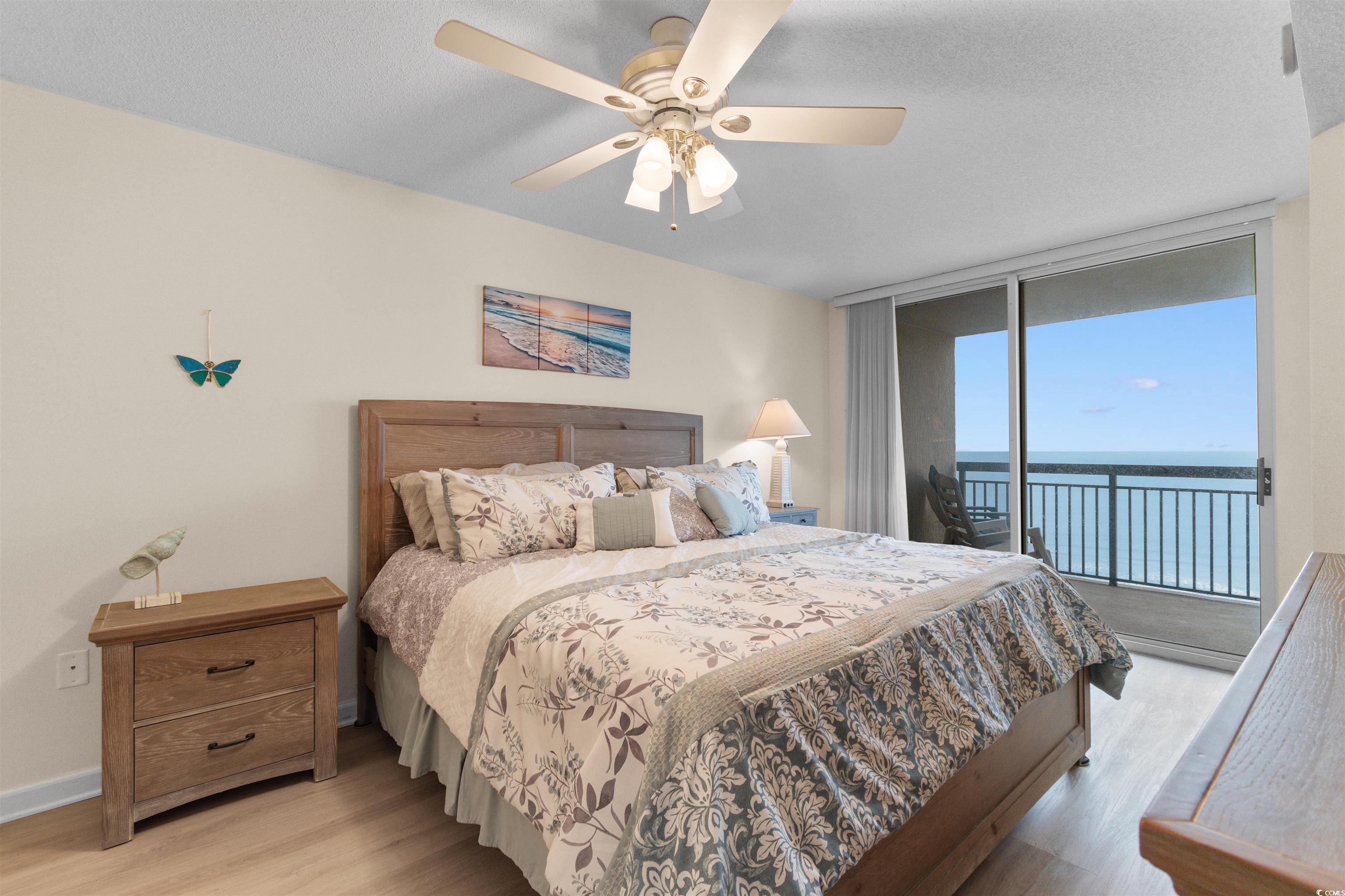 1003 South Ocean Boulevard, Unit 902 North Myrtle Beach, SC 29582 - Photo 16 of 40 Bedroom featuring expansive windows, access to exterior, light wood-style flooring, a textured ceiling, and a ceiling fan