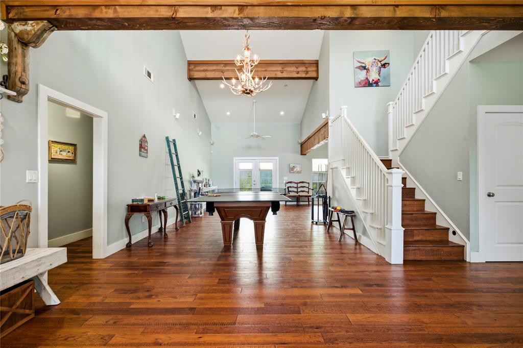 1073 Gordonville Road Gordonville, TX 76245 - Photo 8 of 38 Walk into a grand room that stretches 40+ feet to the back door. Gorgeous beams immediately catch your eye and draw you to the high ceiling in this room. Living areas at both ends with a game area in between welcome you home. The primary suite is the left with staircase leading upstairs on the right. There is also another main floor bedroom to the right on this floor.