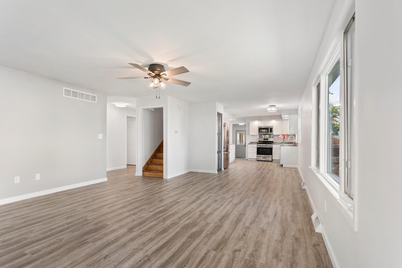 208 Maple Street Ogden, IL 61859 - Photo 6 of 30 a view of a livingroom with wooden floor and a ceiling fan