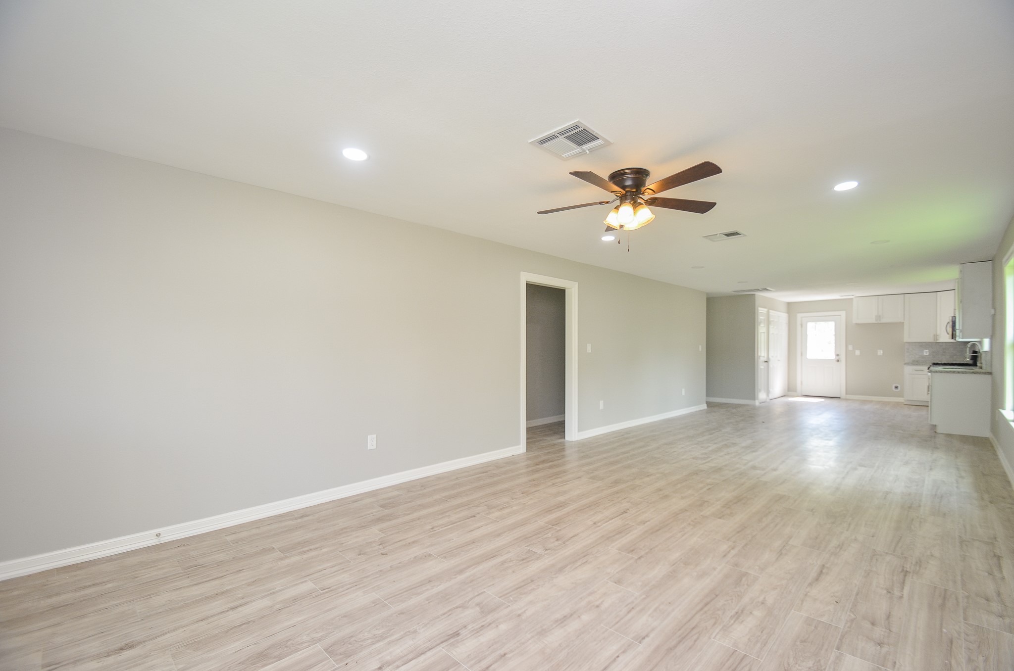 6114 Wedgefield Street Houston, TX 77028 - Photo 17 of 32 a view of an empty room and a ceiling fan & wooden floor