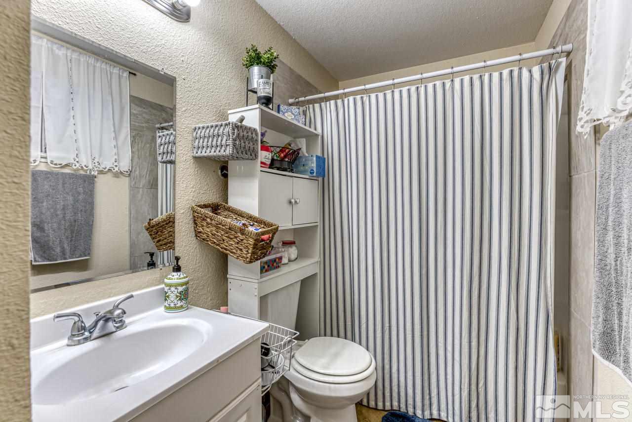 12085 Kernite Street Reno, NV 89506 - Photo 16 of 29 a bathroom with a sink a toilet and shower curtain