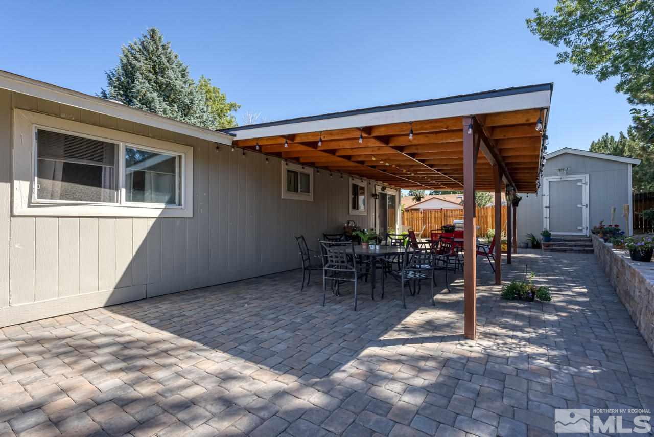 12085 Kernite Street Reno, NV 89506 - Photo 22 of 29 a view of a patio with table and chairs with wooden floor and plants