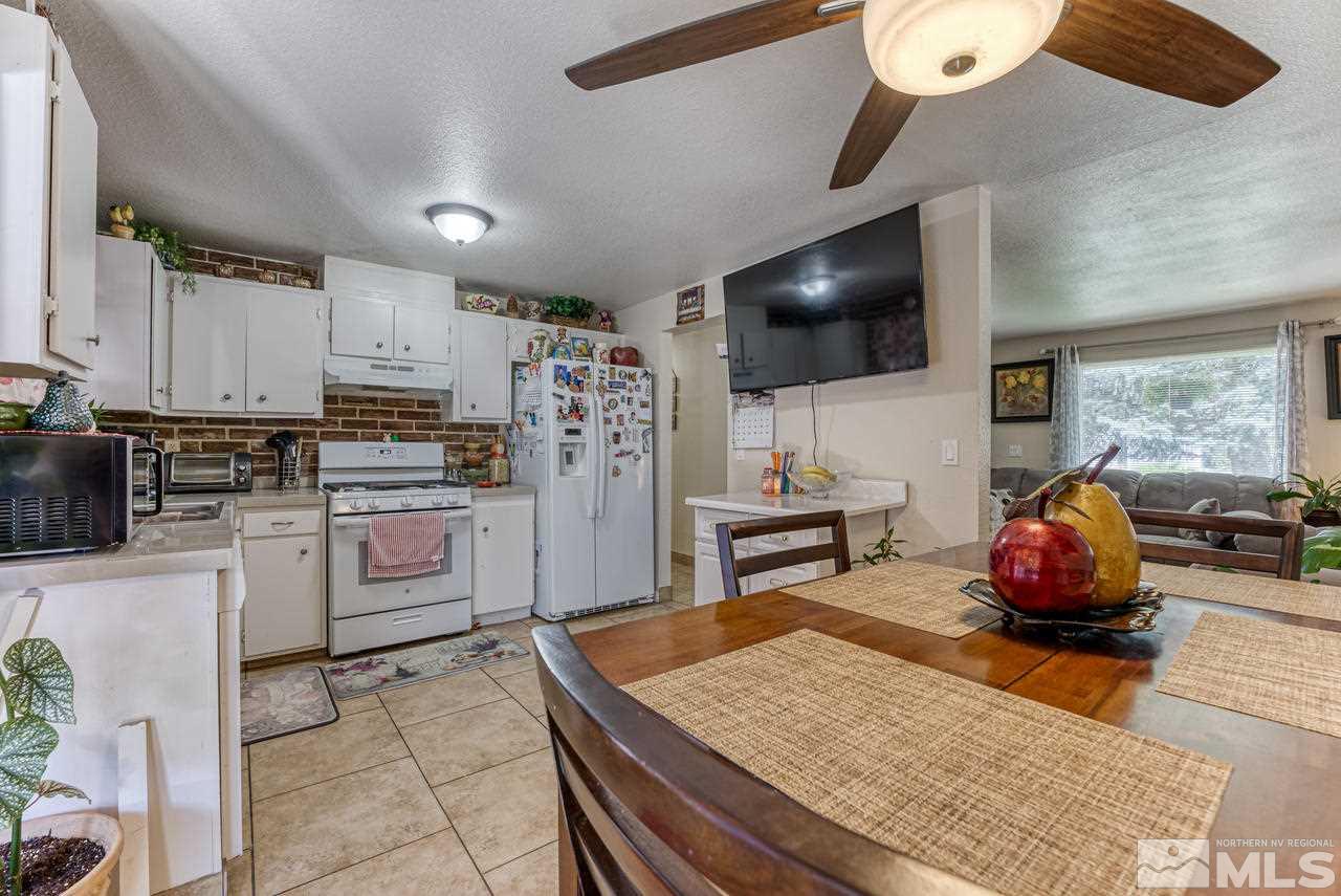 12085 Kernite Street Reno, NV 89506 - Photo 9 of 29 a kitchen with microwave a stove and cabinets