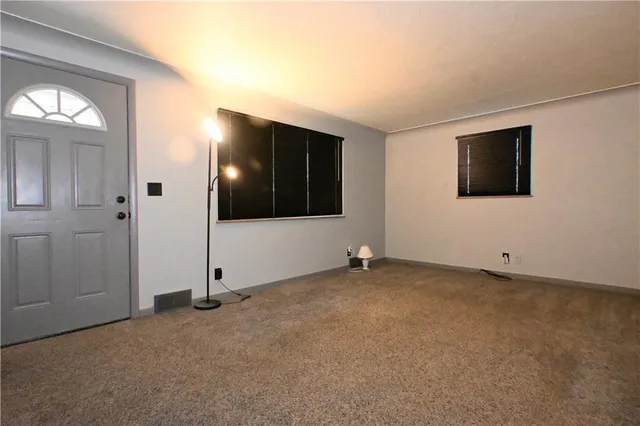 an empty room with windows and television