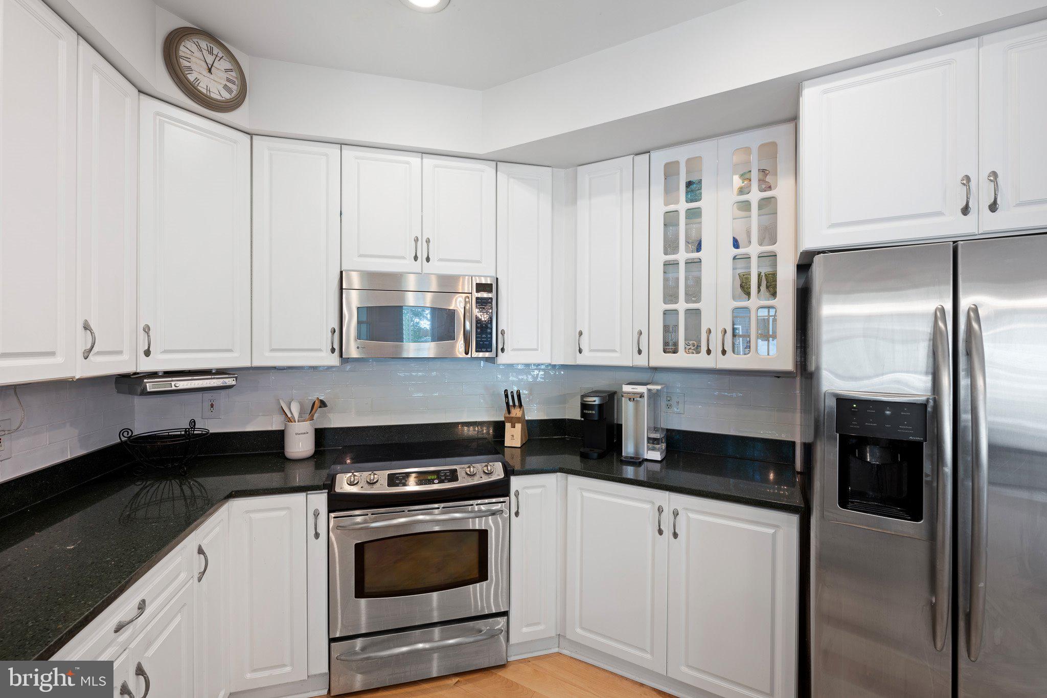718 Foxtail Drive Bethany Beach, DE 19930 - Photo 13 of 39 a kitchen with a refrigerator and white cabinets
