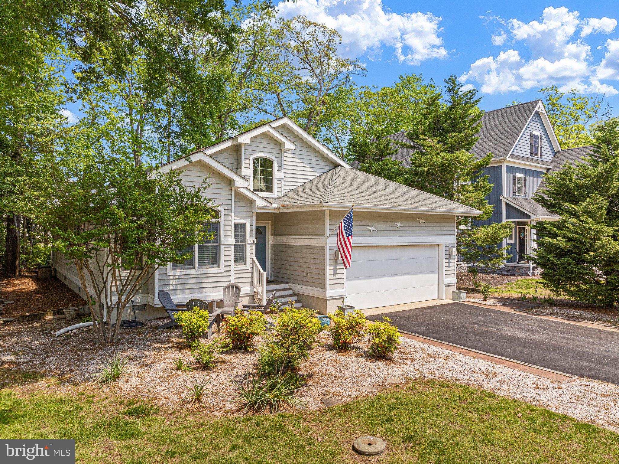 718 Foxtail Drive Bethany Beach, DE 19930 - Photo 2 of 39 a front view of a house with a yard outdoor seating and covered with trees