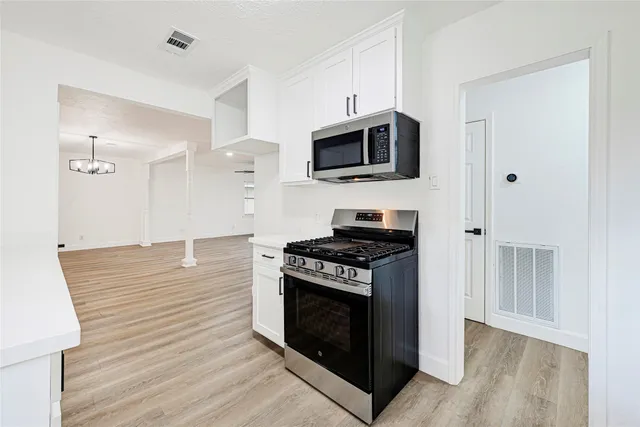 a kitchen with stainless steel appliances a stove microwave and sink