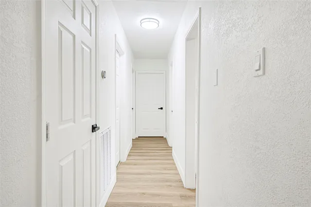a view of a hallway with wooden floor and staircase