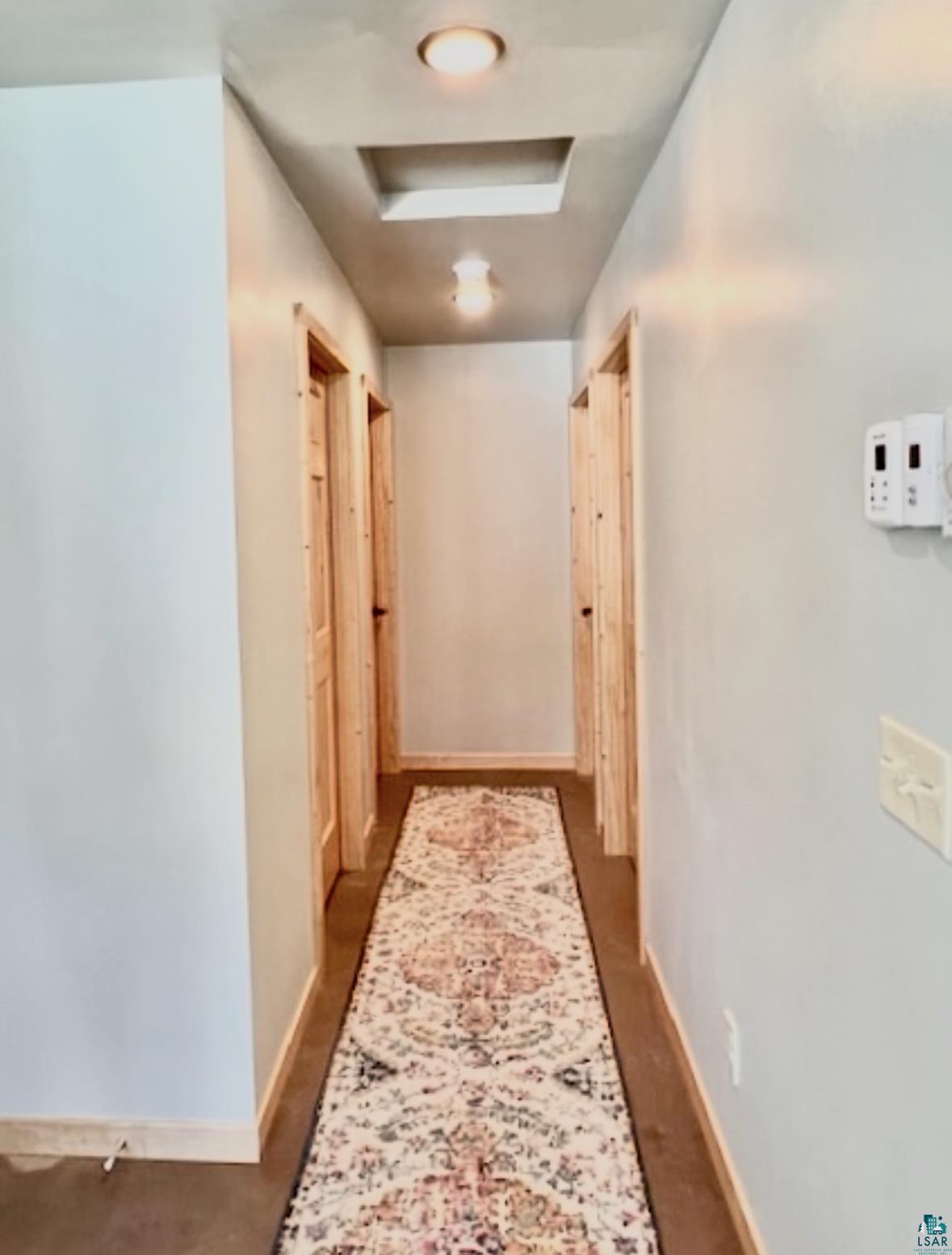 265 Mink Ranch Road Lutsen, MN 55612 - Photo 26 of 36 Hallway with attic access and baseboards