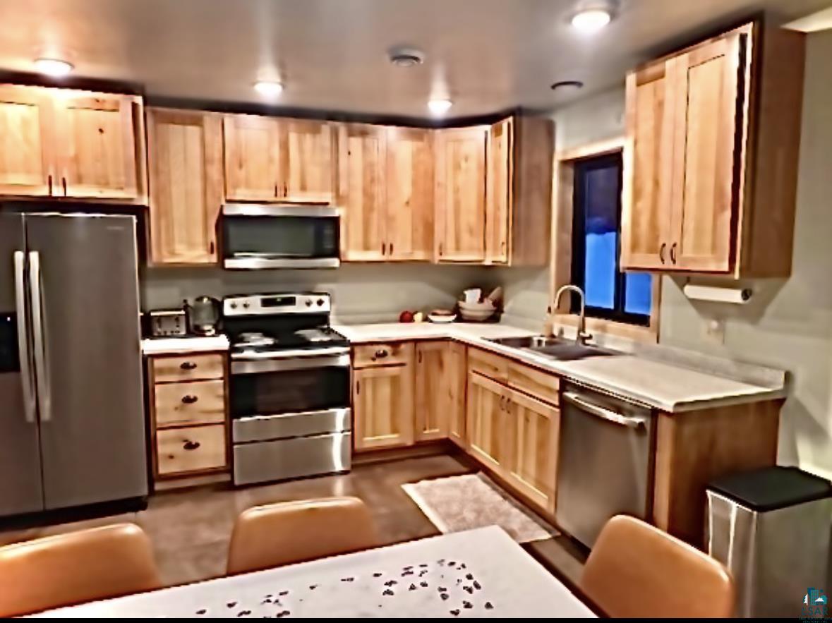 265 Mink Ranch Road Lutsen, MN 55612 - Photo 3 of 25 Kitchen with light wood finish cabinets, stainless steel appliances, and light countertops