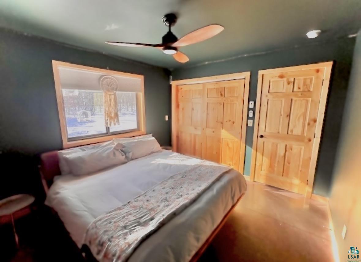 265 Mink Ranch Road Lutsen, MN 55612 - Photo 10 of 25 Bedroom with ceiling fan and a large closet