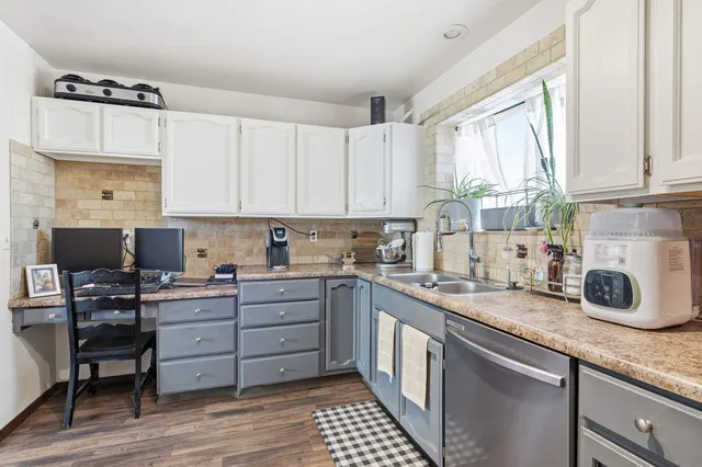 a kitchen with a sink a window and cabinets