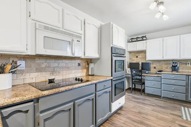 a kitchen with cabinets appliances a sink and a counter space