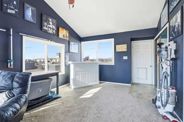 a living room with stainless steel appliances kitchen island granite countertop a refrigerator and a stove top oven