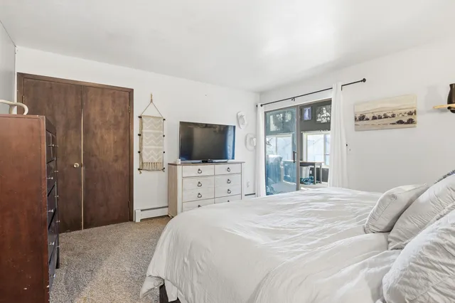 a bedroom with a flat screen tv on dresser and a flat tv screen on dresser