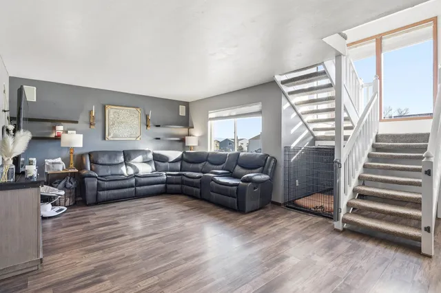 a living room with furniture and a wooden floor