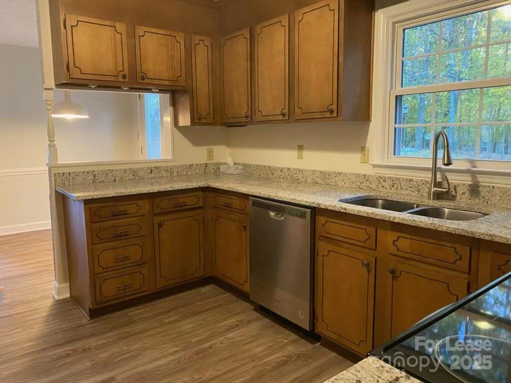7327 Ricewell Road Charlotte, NC 28226 - Photo 11 of 22 a kitchen with stainless steel appliances granite countertop a sink and cabinets with wooden floor