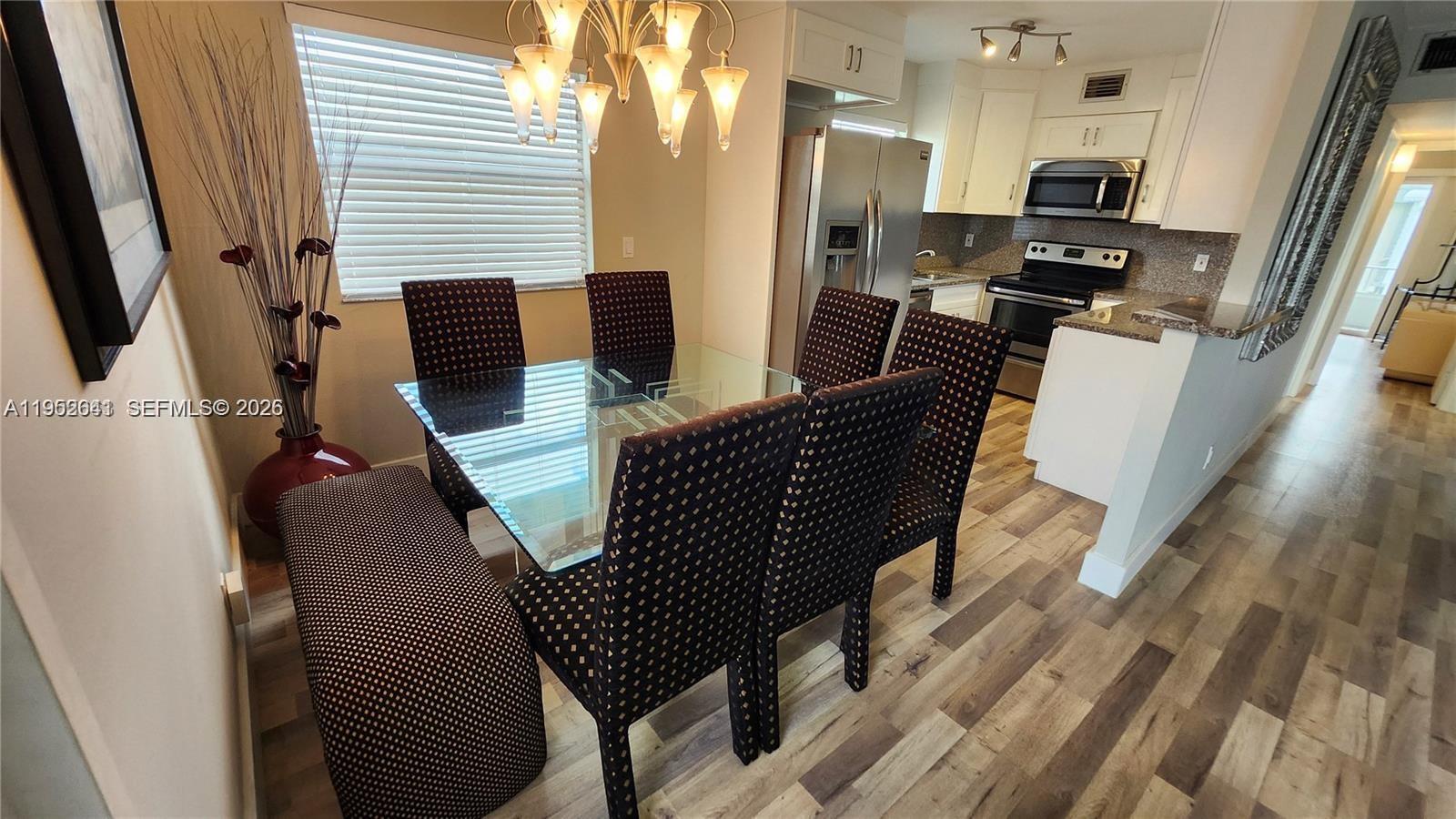 756 Flanders P Delray Beach, Unit 756 Delray Beach, FL 33484 - Photo 6 of 46 a view of kitchen and dining room with wooden floor