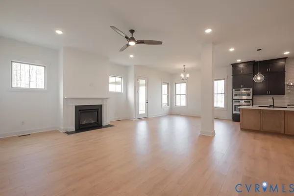 a view of an empty room with a fireplace and window